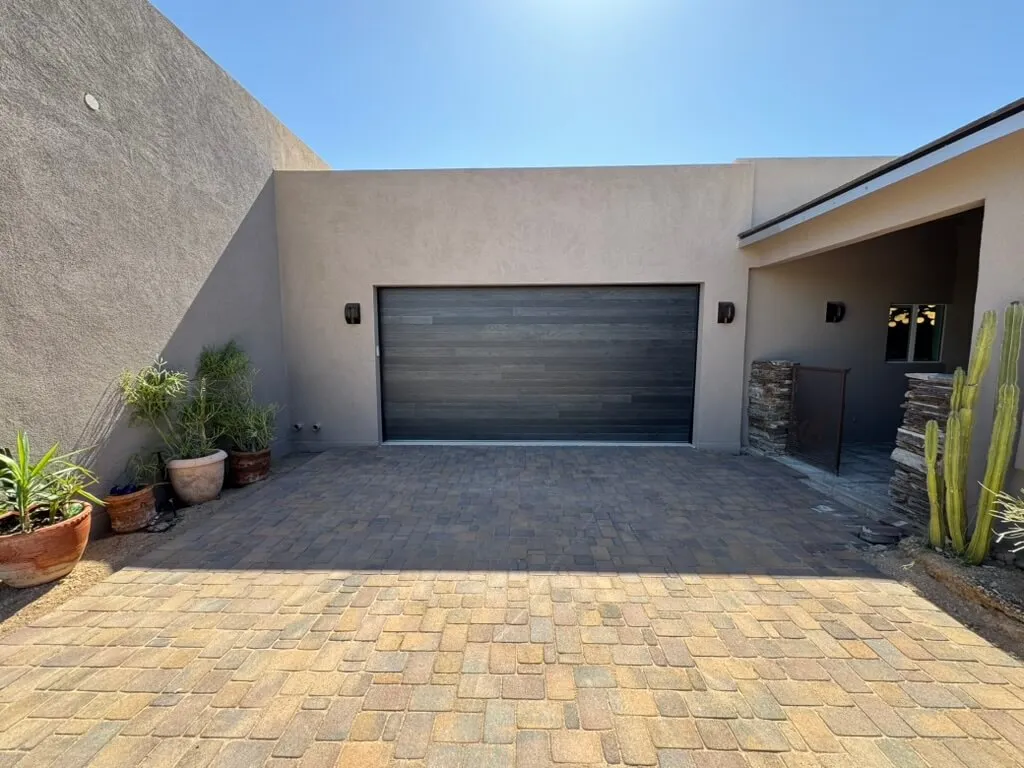 Carbon oak plank 16x8 garage door on a stucco courtyard home