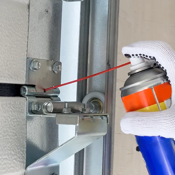 Lubricating garage door hinges during a maintenance visit