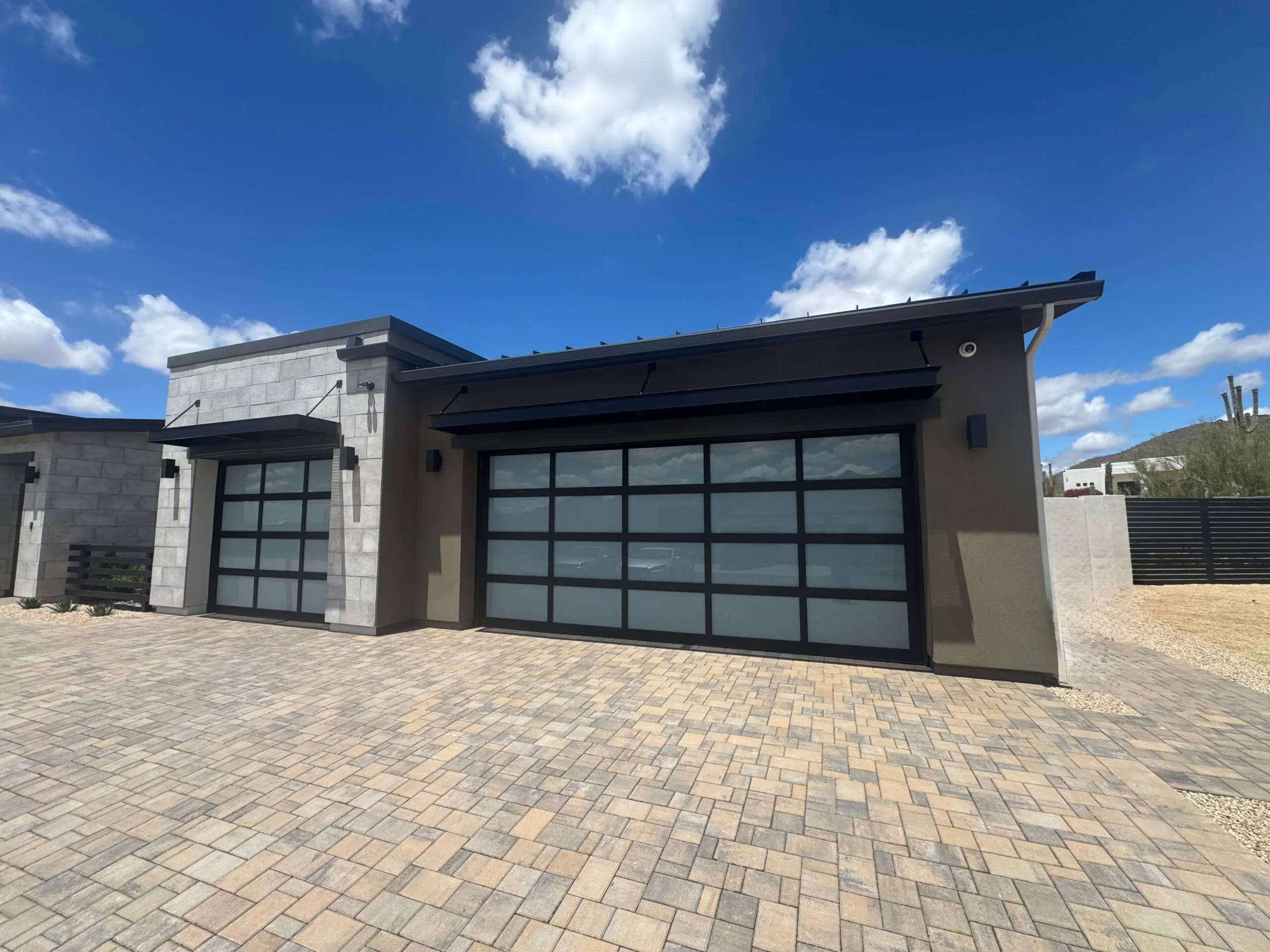 Modern glass and black aluminum garage doors on a Phoenix-area home