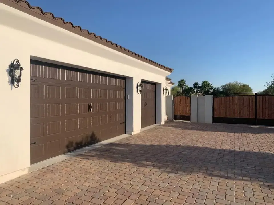 Brown residential garage doors on a Phoenix-area home with a paver driveway