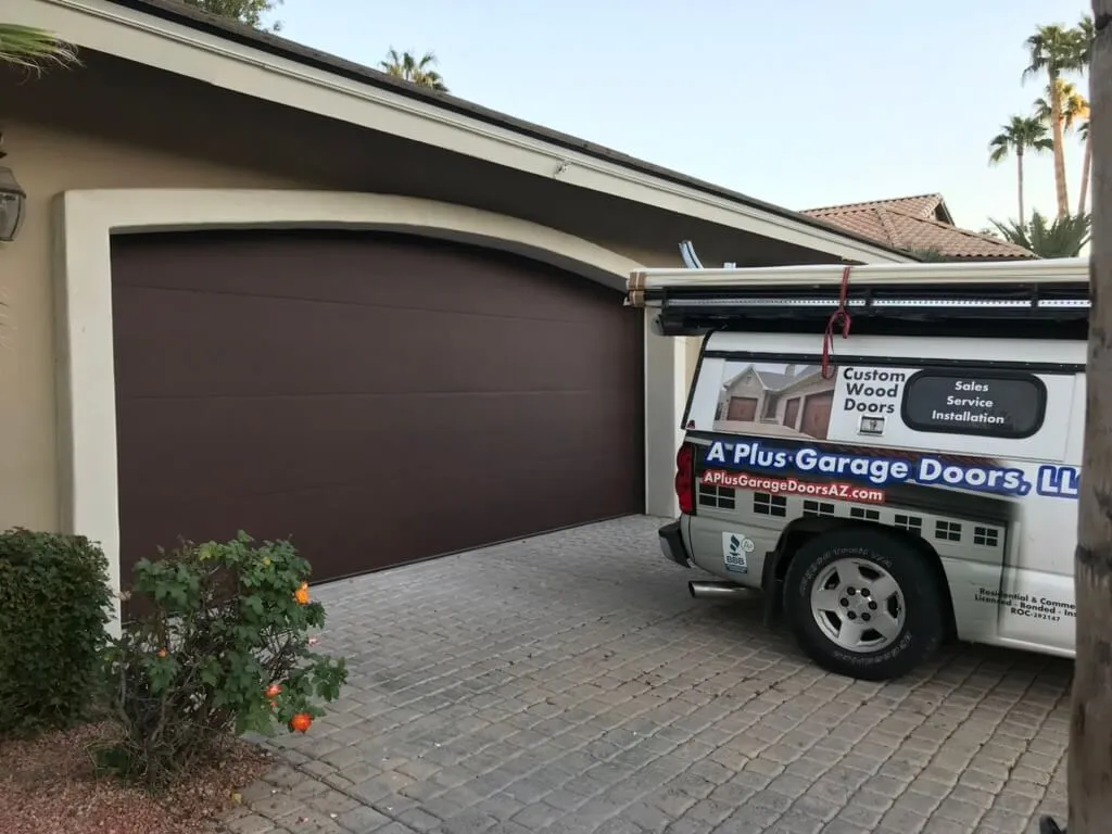 A Plus Garage Doors service van parked at a customer's home